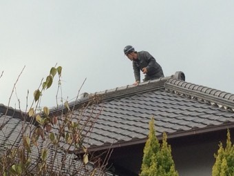 瓦屋根に実際に職人が上がり調査中