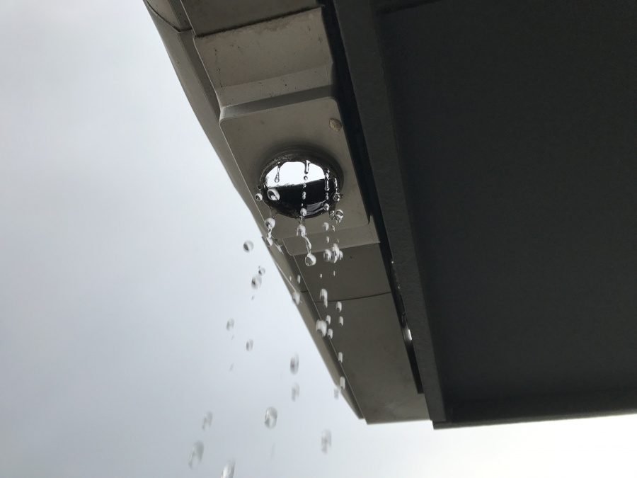 屋根の軒樋の集水器から、雨水が落ちてきています。