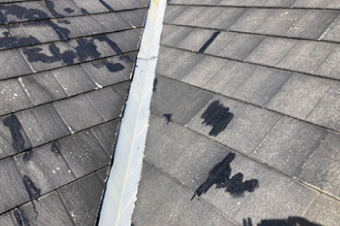 過去の補修後が黒く目立ち、経年劣化を迎えているスレート屋根